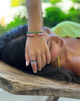 Model wearing Ouro Pink Sapphire Bangle, along with three sided rings and bracelet