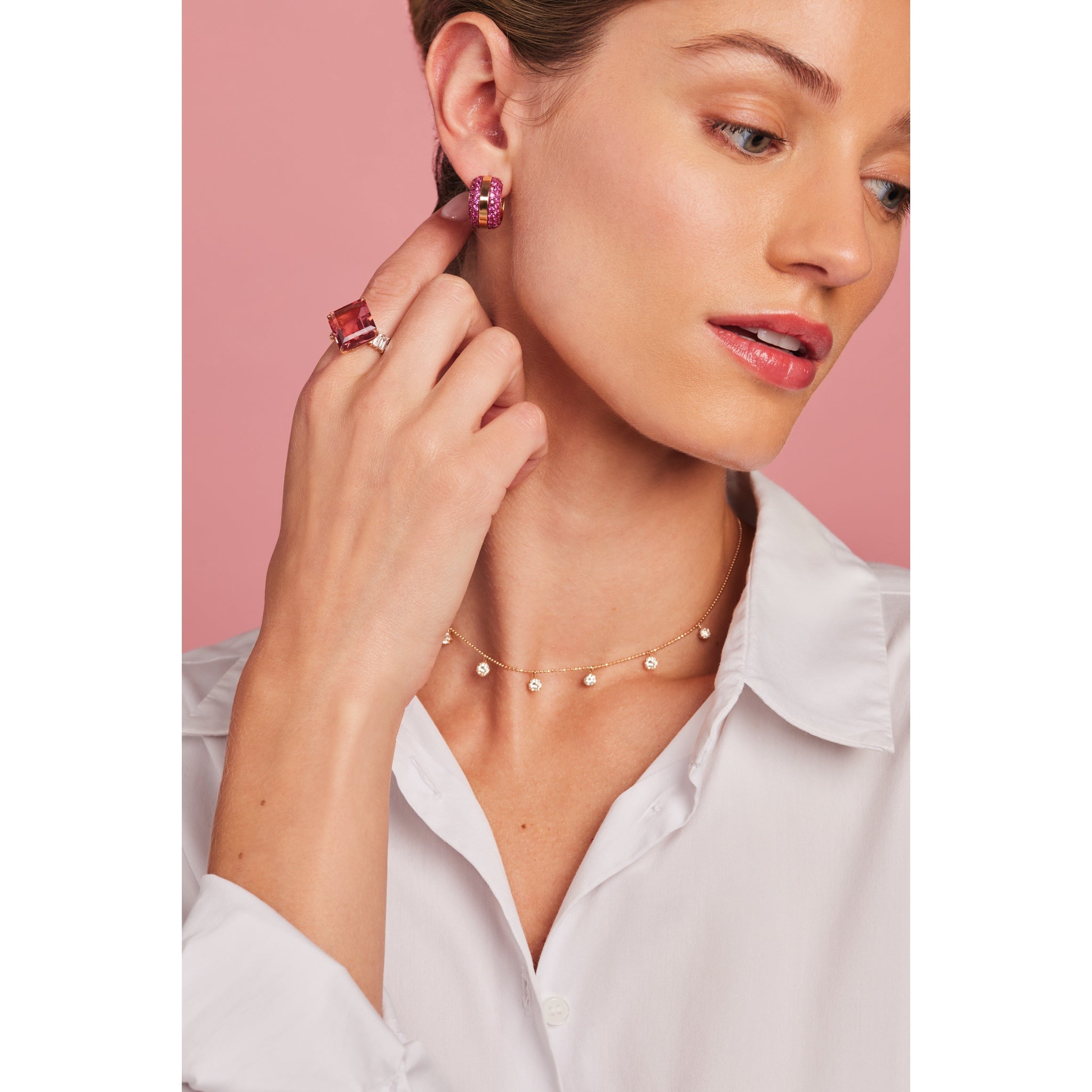 model wearing Ouro Pink Sapphire Hoop Earrings along with other staple pieces in Graziela's jewelry collection