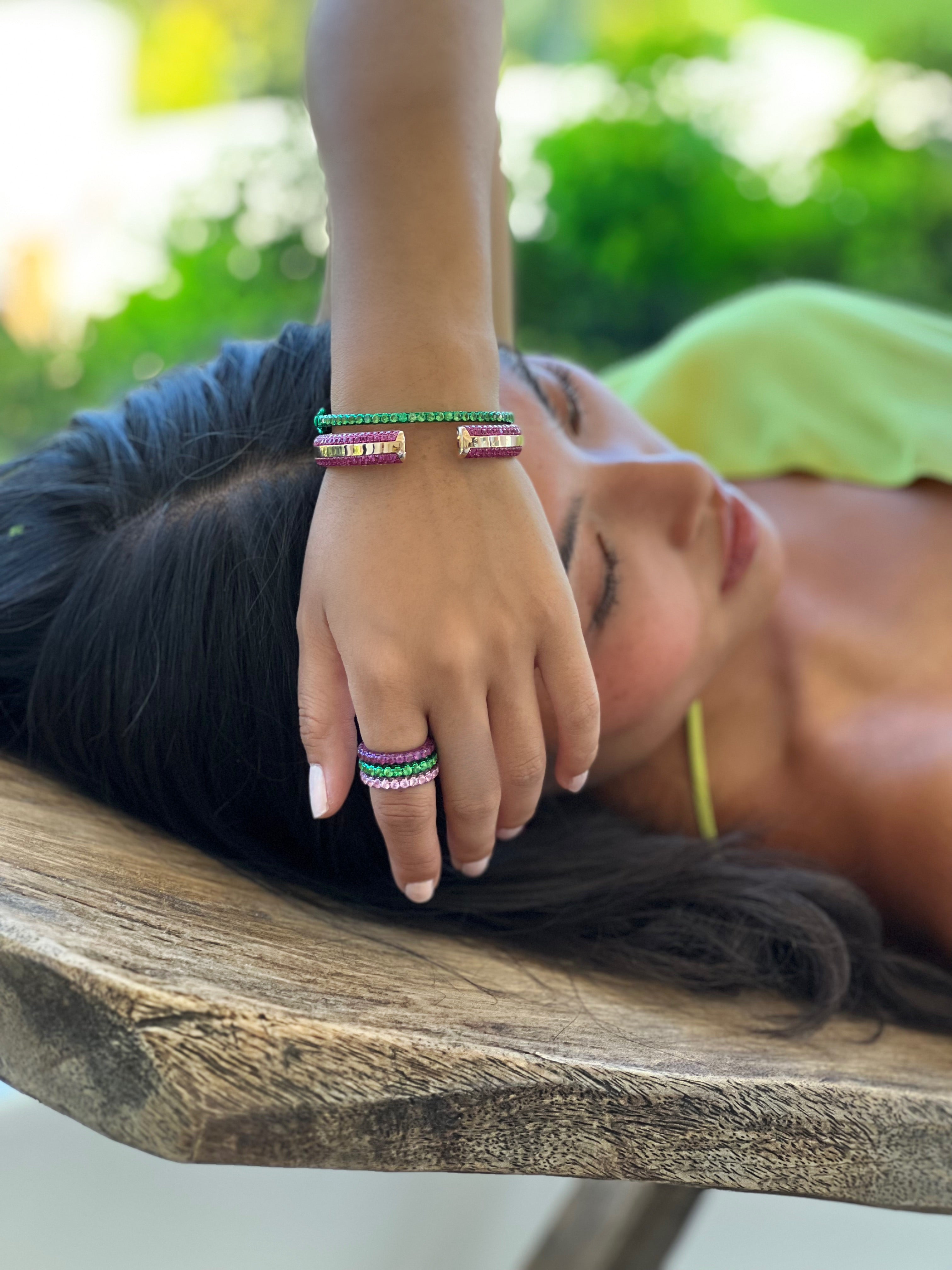 Model wearing Ouro Pink Sapphire Bangle, along with three sided rings and bracelet