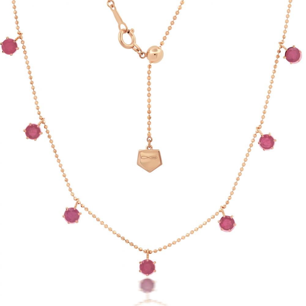 Pink sapphire floating necklace with rose gold metal and additional pink sapphire accents, featuring an adjustable bolo chain.