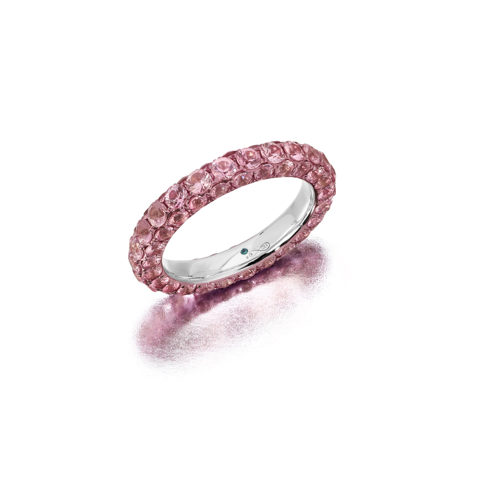 A pink sapphire and pink rhodium three-sided ring with a band of pink rhodium on either side and pink sapphire stones embedded in the middle band.